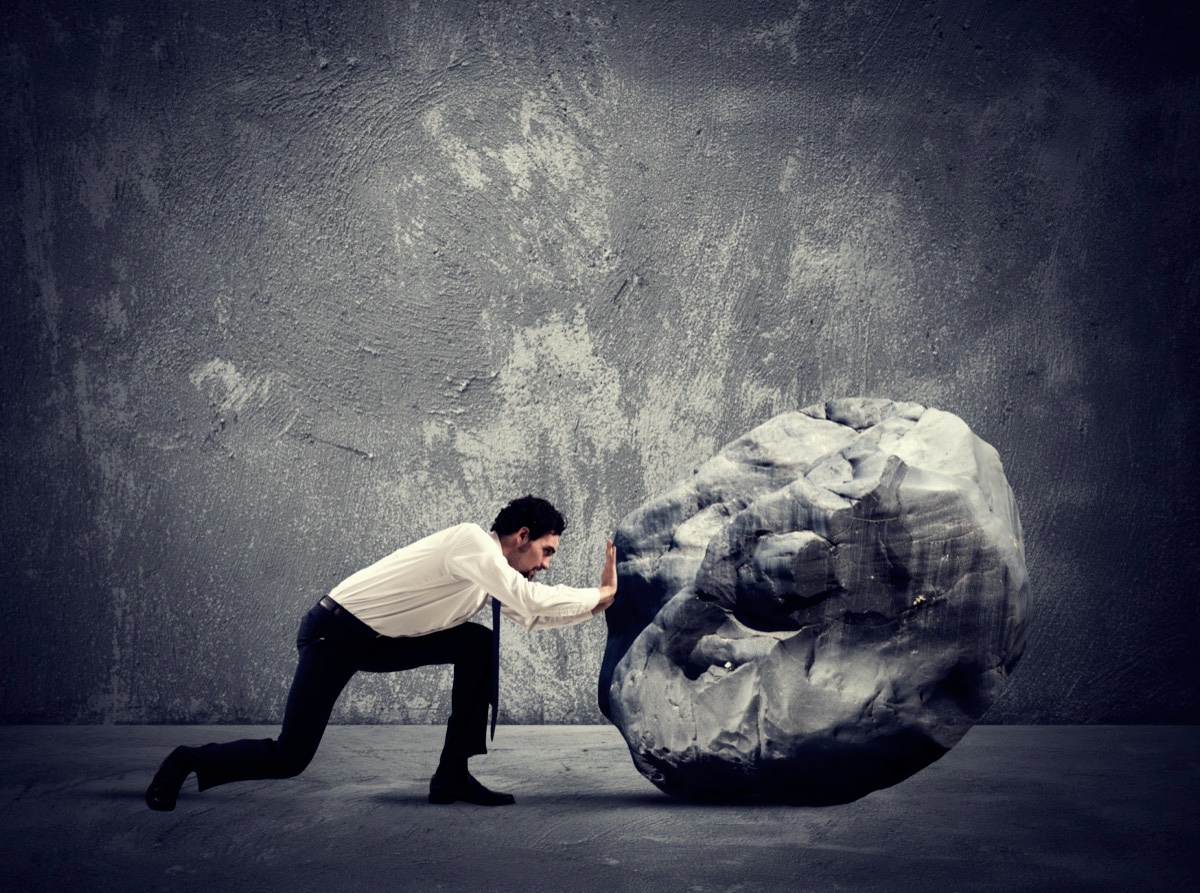 freepik-businessman-pushing-a-heavy